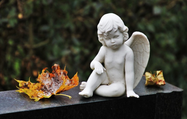 Статуэтка белого ангела с желтыми листьями