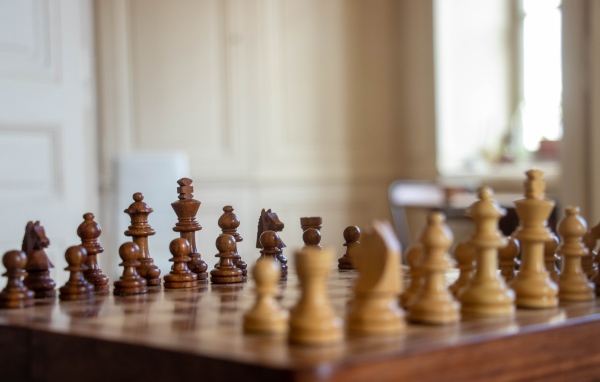 Деревянные шахматы на доске у окна