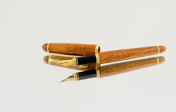 Деревянная ручка перо на сером фоне