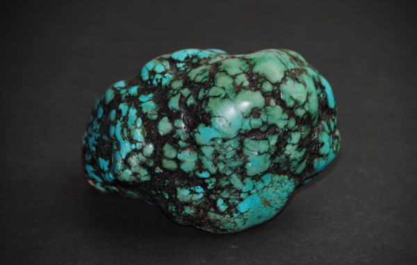 Драгоценный камень бирюзы на сером фоне