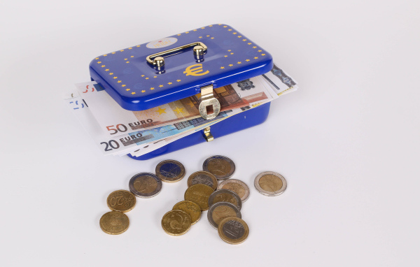 Синяя копилка чемодан с деньгами и монетами на сером фоне