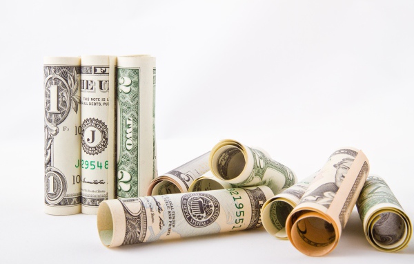 Скрученные в трубочки доллары на белом фоне 