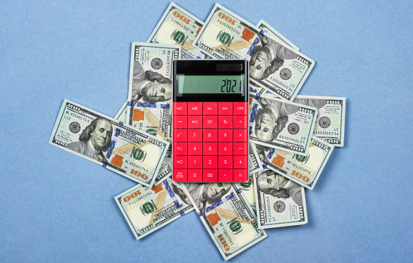 Много долларов с калькулятором на синем фоне