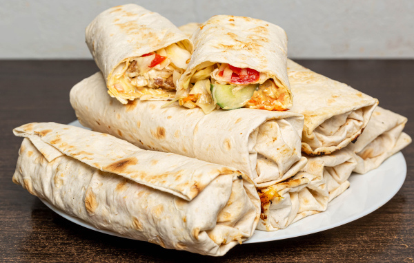 Аппетитная шаурма в лаваше на столе 