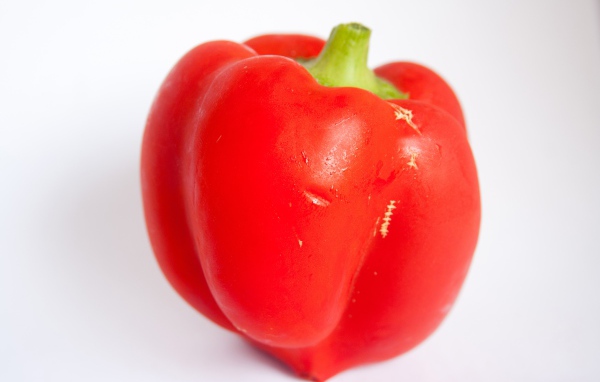 Большой красный болгарский перец на сером фоне