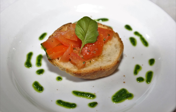 Брускетта на тарелке с помидорами и соусом