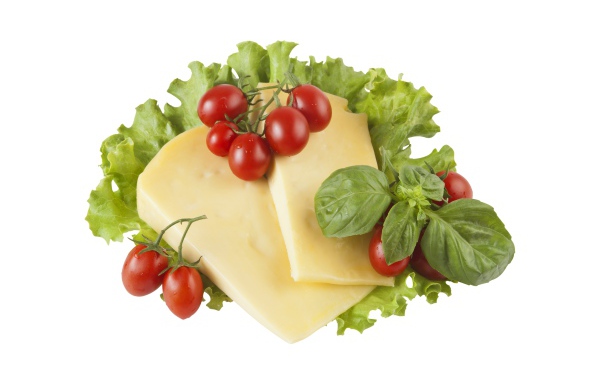Сыр с помидорами, листьями салата и базиликом на белом фоне