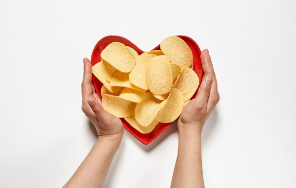 Чипсы в красной тарелке на белом фоне