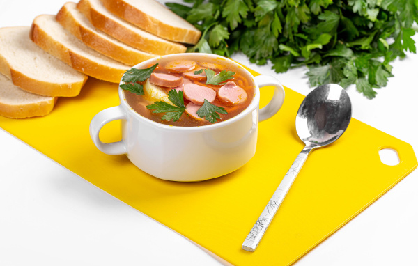 Вкусный суп солянка на столе с хлебом и петрушкой