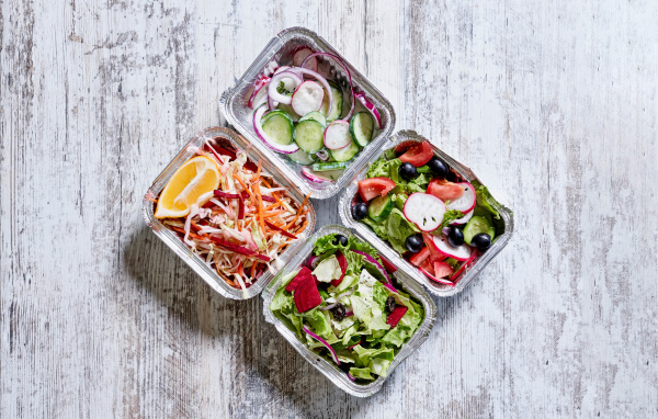 Разные овощные салаты в тарелках на сером столе 