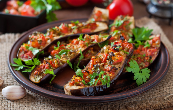 Баклажаны начиненные овощами на тарелке 