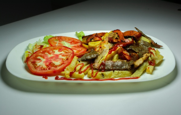 Картофель фри на тарелке с помидорами 