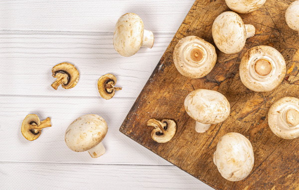 Свежие шампиньоны на разделочной доске