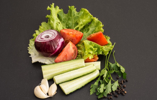 Свежие помидоры, огурцы, лук и листья салата 