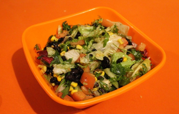 Салат из свежих овощей на оранжевом фоне