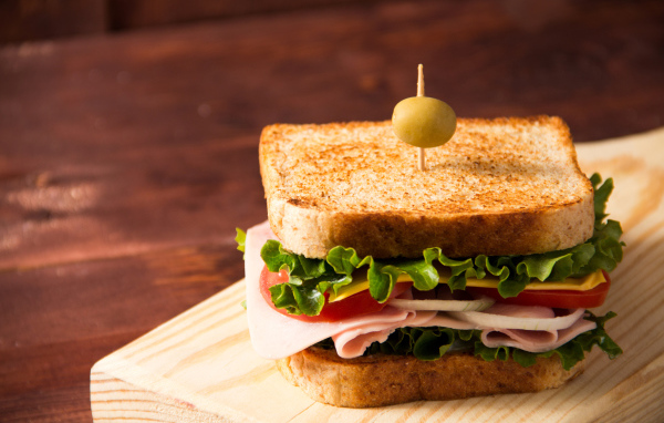 Гамбургер с ветчиной, помидорами, листьями салата и сыром