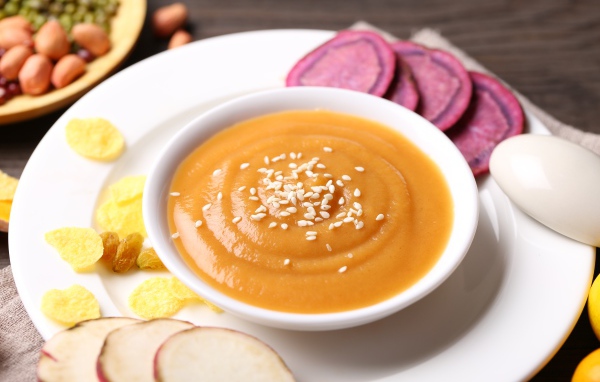 Гороховое пюре в белой тарелке с овощами