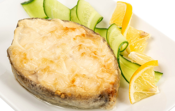 Картофель с сыром на тарелке с огурцами и лимоном 