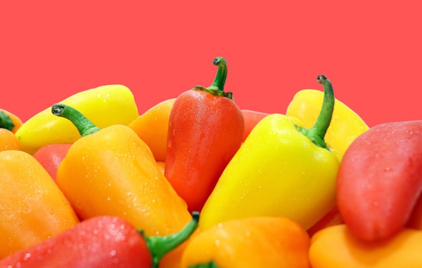 Красный и желтый перец на розовом фоне 