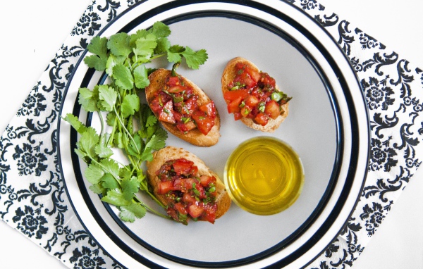 Бутерброды с помидорами на тарелке с петрушкой и маслом