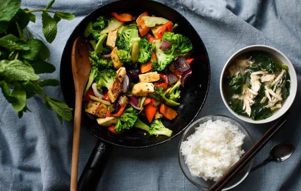 Овощи на сковороде на столе с рисом и спаржей