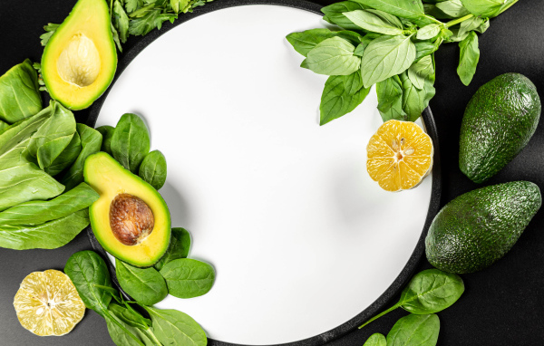 Авокадо с листьями базилика на белом фоне