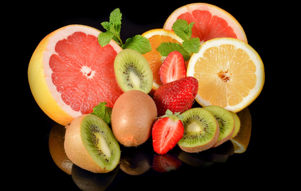 Цитрусовые фрукты с клубникой на черном фоне