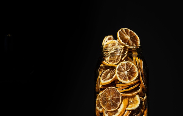 Сушеные лимоны в банке на черном фоне