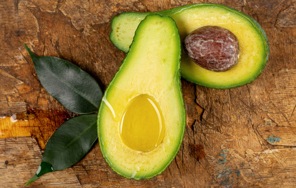 Зеленое авокадо на деревянном столе