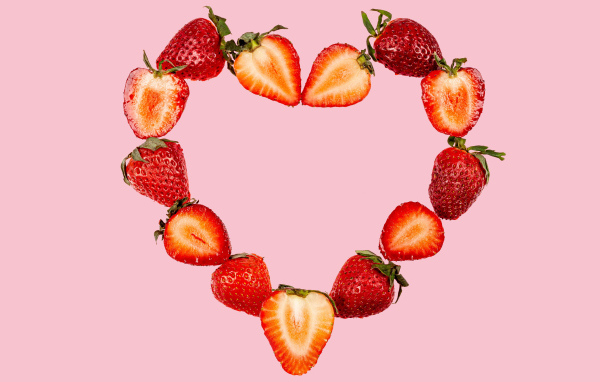 Сердце из клубники на розовом фоне 