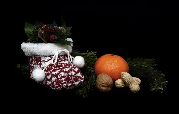 Мандарин с орехами и украшениями на черном фоне 