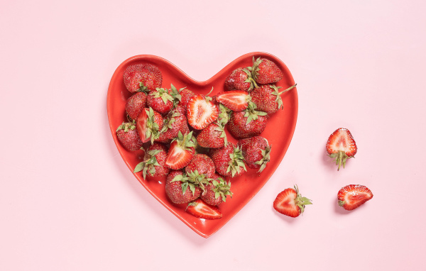 Красная тарелка в форме сердца с клубникой 