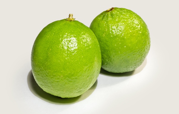 Два больших зеленых лайма на столе