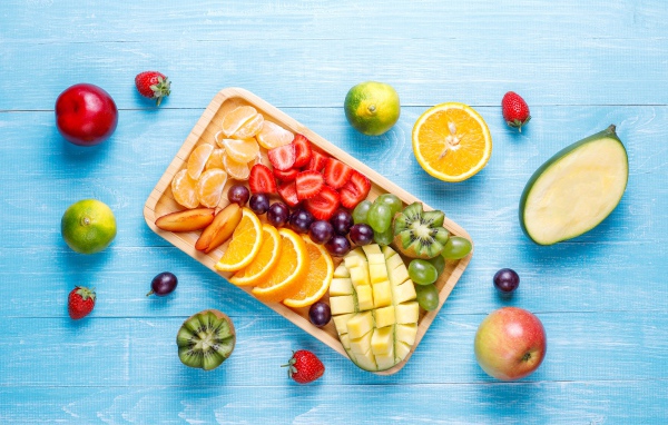 Деревянная доска с нарезанными свежими фруктами