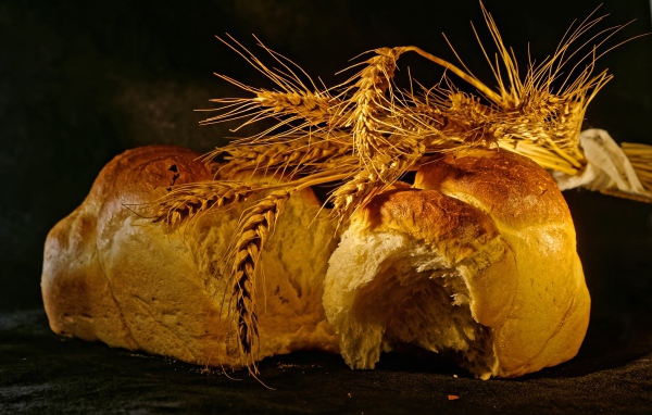 Свежий хлеб с колосьями пшеницы на столе