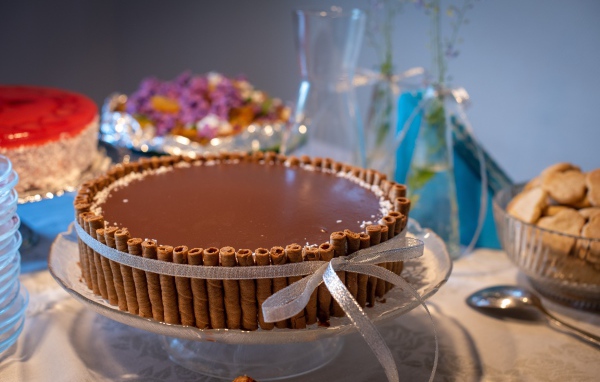 Большой шоколадный торт с трубочками на столе