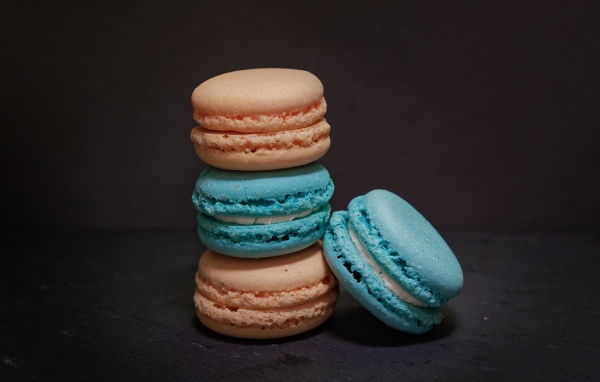 Голубой и коричневый десерт макарун на сером фоне