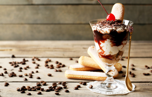 Десерт с печеньем савоярди на столе с кофейными зернами