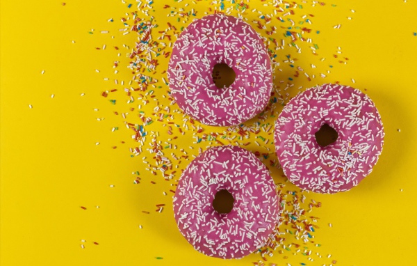 Пончики с розовой глазурью на желтом фоне