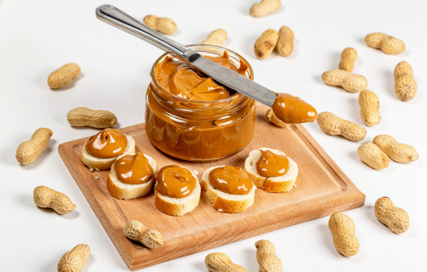 Ореховая паста на столе с батоном и арахисом