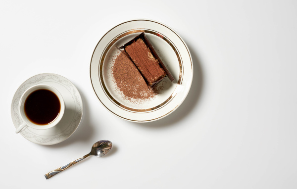 Кусок торта на столе с чашкой кофе 