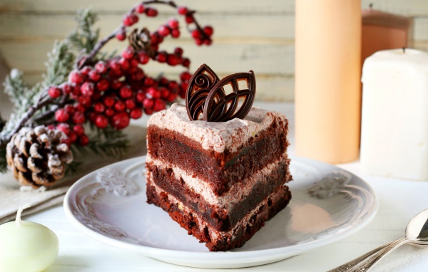 Кусок шоколадного торта на белой тарелке на столе