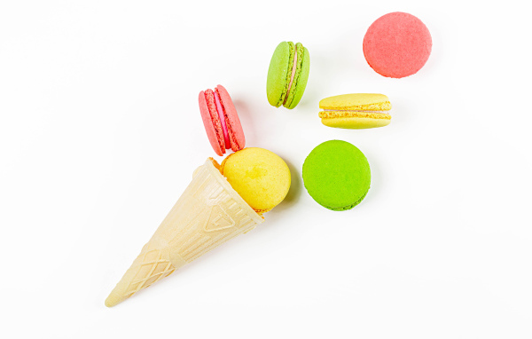 Вафельный рожок с печеньем макарун на белом фоне