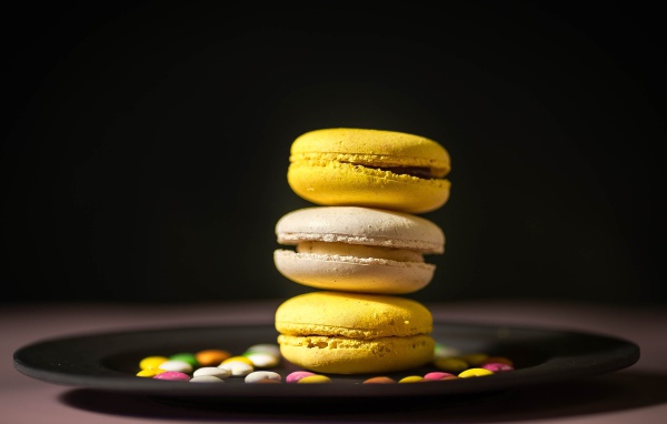 Желтый десерт макарун на тарелке