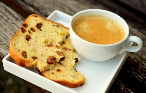 Чашка кофе на тарелке с кусочками кекса 