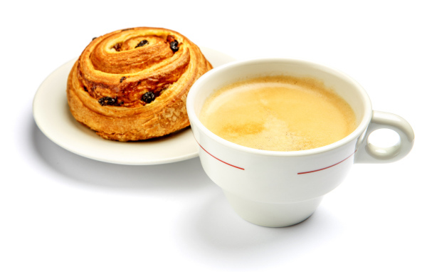 Чашка кофе с булочкой на столе