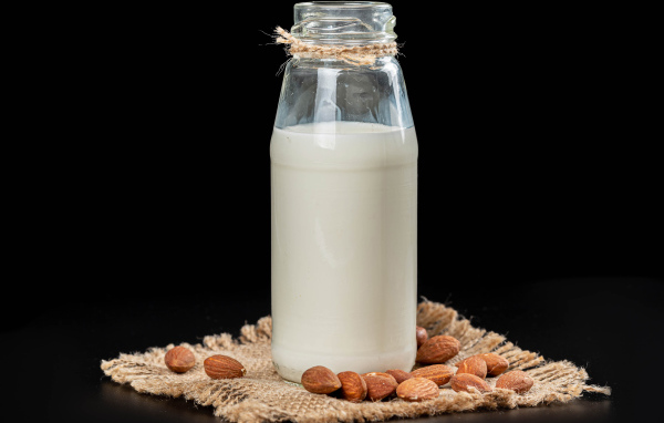 Молоко с миндалем на черном фоне