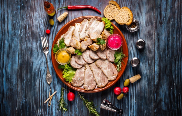 Meat platter in a plate with sauce and herbs