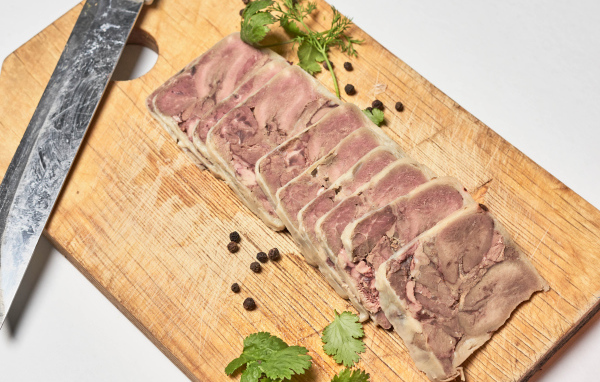 Мясной продукт на деревянной доске с ножом 