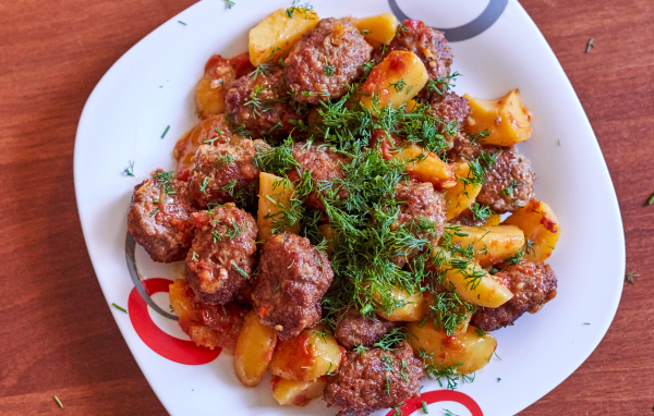 Фрикадельки с картофелем и укропом на белой тарелке